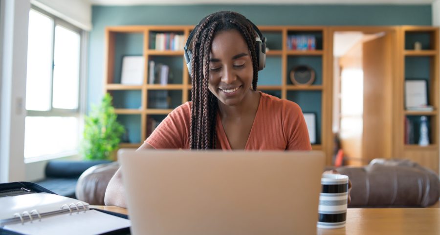 Woman working at home. Home office. Portrait of a woman on a video call with laptop and headphones while working from home. Home office concept. New normal lifestyle.